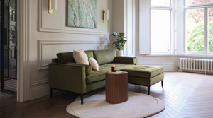 green velvet sofa with white circular rug