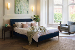 Upholstered bed in a sunlit room 