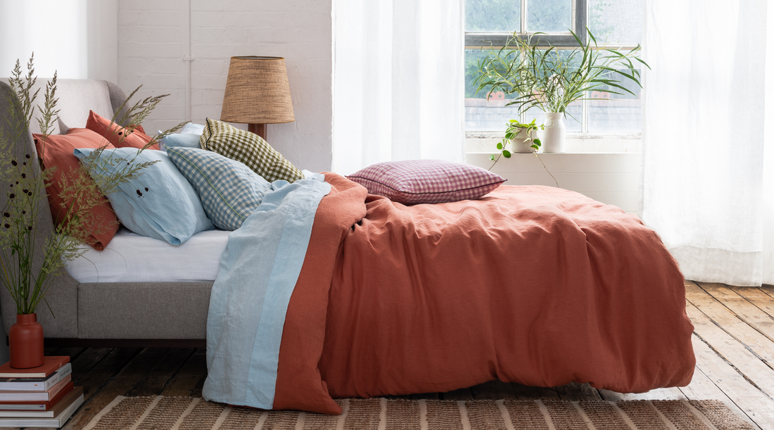 grey winged headboard bed with red and blue bed linen