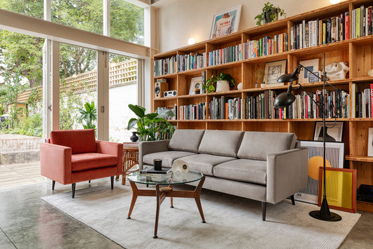 living room with bookcase, grey sofa and red/orange armchair